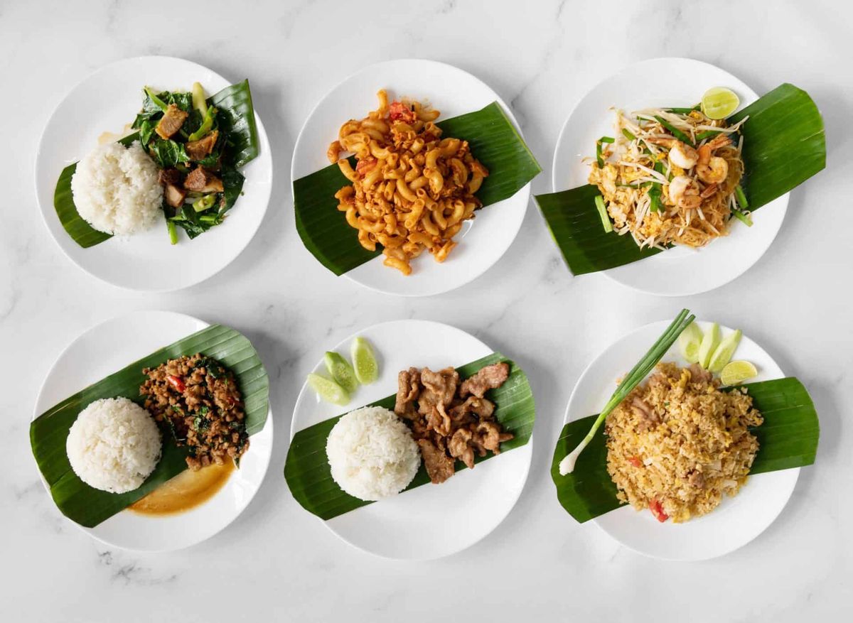 Six banana-leaf plates of made-to-order Thai dishes over rice, from basil pork to pad thai and fried rice