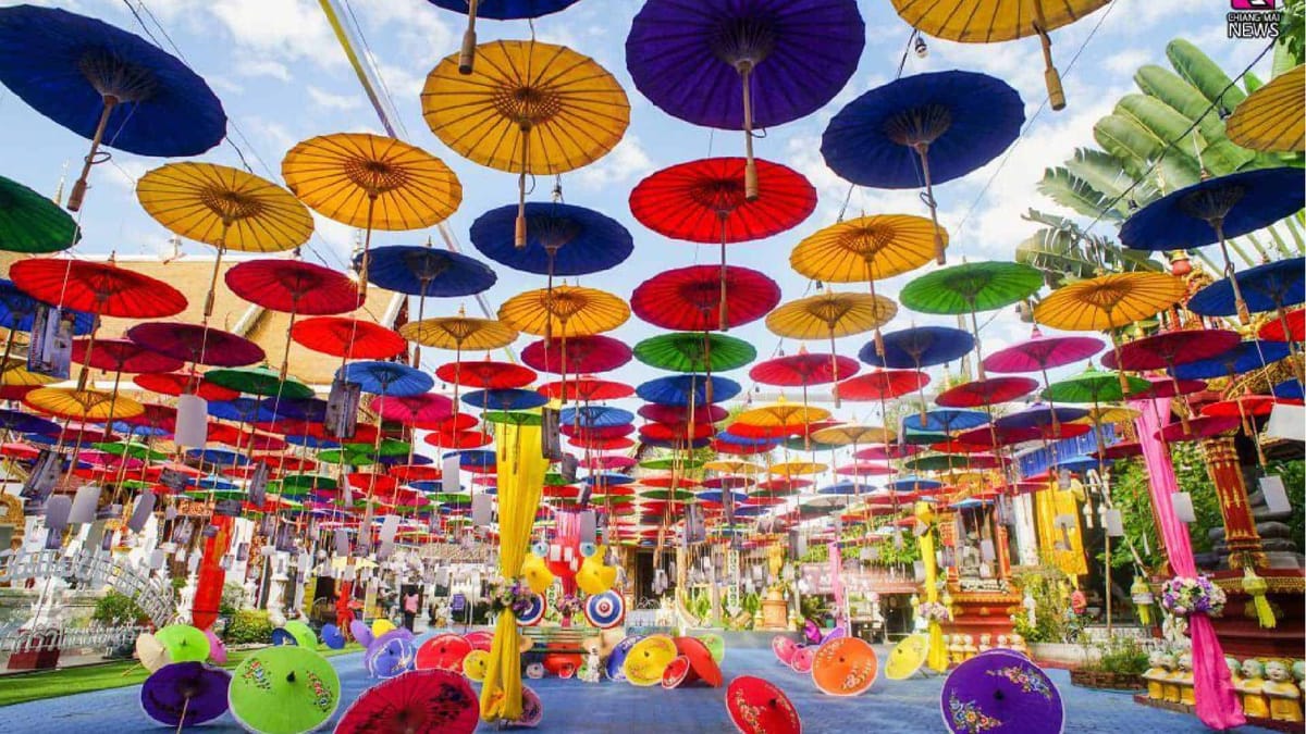 Hundreds of colorful hand-painted Lanna paper umbrellas hung overhead at the Bo Sang Umbrella Festival under a blue sky
