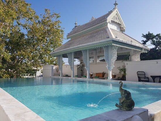 Inside House courtyard pool with a bronze elephant fountain beside an ornate white Lanna pavilion