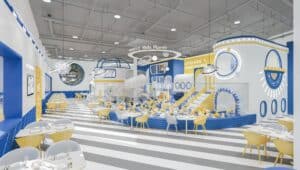 Blue, yellow and white striped interior of Little Soul Kids Planet play cafe with dining tables