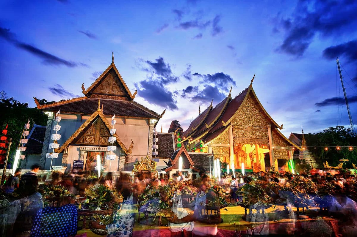 Wat Chedi Luang temple lit at dusk with crowds gathered for the Inthakin City Pillar Festival in the Old City