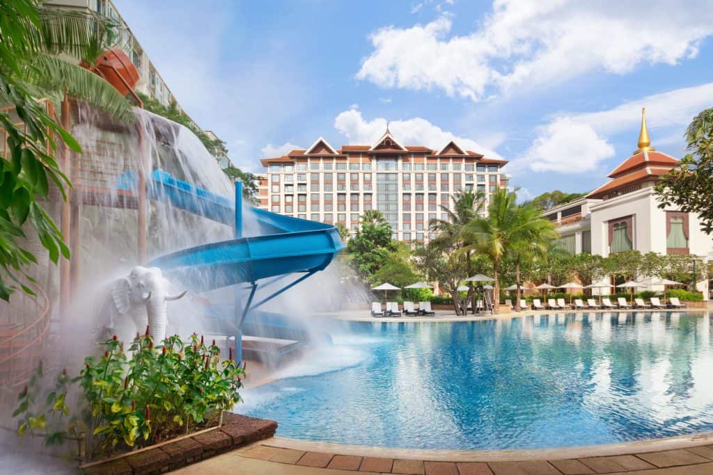 Shangri-La's free-form tropical pool with a blue water slide, elephant waterfall and palm trees