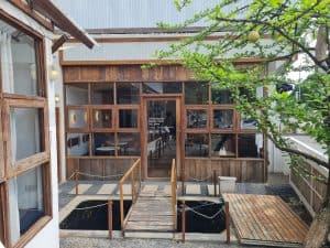 Sukhum Caffe Sanpatong's charming timber-and-glass building with a wooden deck entrance