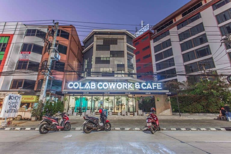 Colab Cowork & Cafe multi-story building exterior with motorbikes parked along the street in Chiang Mai