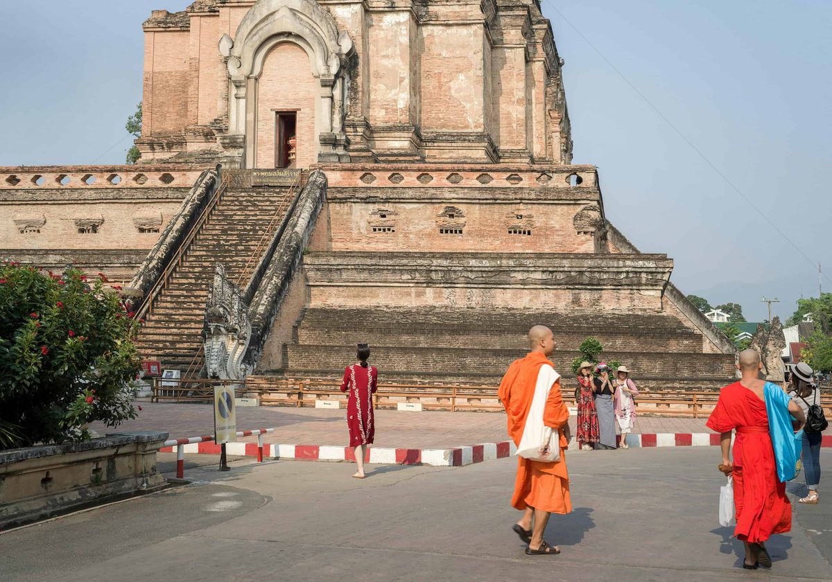 Monks and visitors before the ancient brick chedi of Wat Chedi Luang, Chiang Mai