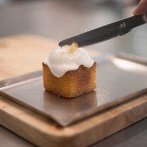 Icing being spread over a square butter cake at Graph Contemporary