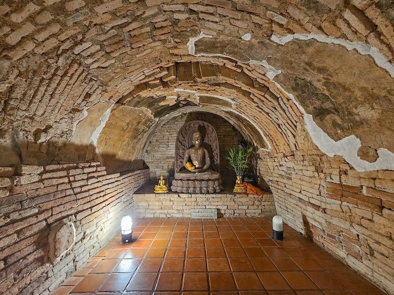 Ancient brick meditation tunnel enshrining a seated Buddha image at Wat Umong near Chiang Mai University