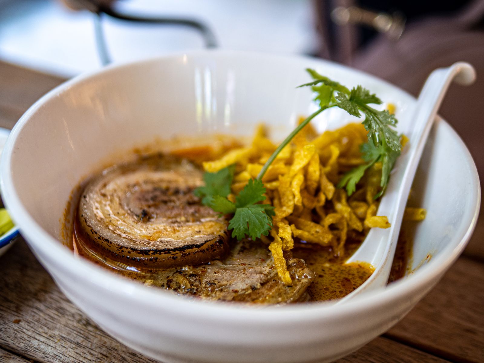 A bowl of khao soi — Northern Thai curry noodle soup with crispy noodles and fresh cilantro